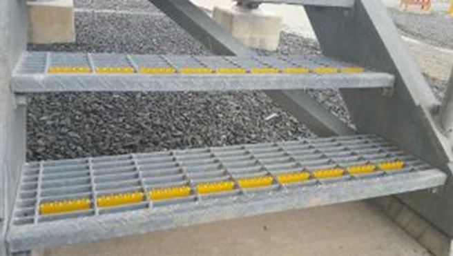 Close-up of U-Tred anti-slip stairnosings used on steel grate steps.